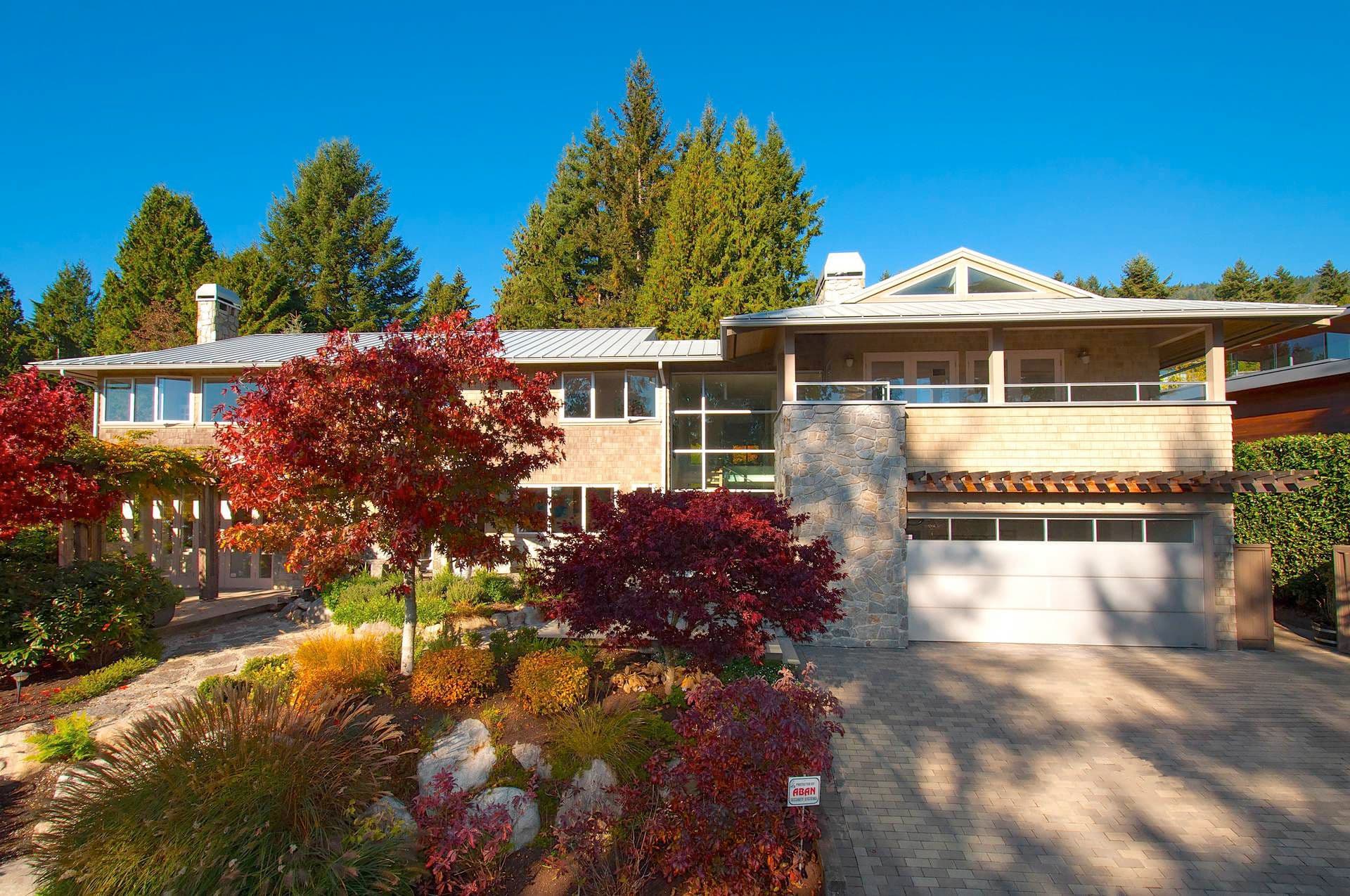 Cedar-shingled home with stone accents and autumn landscaping